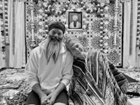 a man with a beard and a woman sitting on a blanket